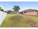 Backyard view showcasing a large grassy area and white fence at 2720 S Biscayne Dr, North Port, FL 34287