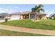 Single-story house with a landscaped lawn and palm trees at 2720 S Biscayne Dr, North Port, FL 34287