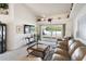 Living room features a large TV, comfortable seating, and a view to backyard at 2720 S Biscayne Dr, North Port, FL 34287