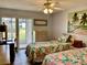 Bright bedroom with two twin beds, a desk, and patio access at 305 47Th Avenue W Dr # 143, Bradenton, FL 34207