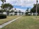 Exterior view of an apartment community with lush landscaping and a walkway at 305 47Th Avenue W Dr # 143, Bradenton, FL 34207