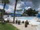 Refreshing community pool with surrounding patio furniture and tropical landscaping at 305 47Th Avenue W Dr # 143, Bradenton, FL 34207