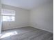 Spacious bedroom with neutral walls, wood-look vinyl flooring, and a window with blinds at 3259 Beneva Rd # 102, Sarasota, FL 34232