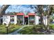 Two-story condo building with red tile roofs, screened balconies, and landscaping at 3259 Beneva Rd # 102, Sarasota, FL 34232