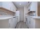 Modern kitchen with white cabinets, updated appliances, and wood-look vinyl flooring at 3259 Beneva Rd # 102, Sarasota, FL 34232