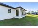 Covered back patio with outdoor kitchen and grassy backyard at 3782 Horace Ave, North Port, FL 34286