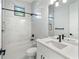 Modern bathroom with marble shower, white vanity, and black fixtures at 3782 Horace Ave, North Port, FL 34286