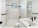 Modern bathroom with marble shower, white vanity, and black fixtures at 3782 Horace Ave, North Port, FL 34286