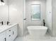 Elegant bathroom with soaking tub, double vanity, and marble tile at 3782 Horace Ave, North Port, FL 34286