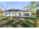 Side view of a house showcasing a modern design and a grassy yard at 3782 Horace Ave, North Port, FL 34286