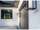 Dark gray garage door and white exterior wall with black window at 3782 Horace Ave, North Port, FL 34286