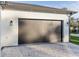 Modern garage with dark gray door and paver driveway at 3782 Horace Ave, North Port, FL 34286