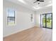 Living room with wood-look floors, sliding glass doors, and ceiling fan at 3782 Horace Ave, North Port, FL 34286