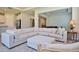 Living room features sectional sofa, ottoman, and view into kitchen and dining areas at 4326 Silo Port Ct, Lakewood Ranch, FL 34211