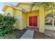 Inviting red front door entryway to a yellow house at 4581 E Dover Street Cir, Bradenton, FL 34203