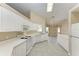 Kitchen with white cabinets, tile floors, and appliances at 4581 E Dover Street Cir, Bradenton, FL 34203
