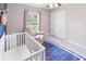 Bedroom featuring a crib, armchair, and window with natural light at 4892 Hillman Ter, North Port, FL 34288