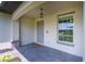Front entry with paver porch and gray door at 4892 Hillman Ter, North Port, FL 34288