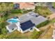 Aerial view of a home featuring a pool, solar panels and lush landscaping at 5179 Flicker Field Cir, Sarasota, FL 34231