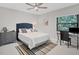 Bright bedroom with a queen-size bed, desk, and ceiling fan at 5179 Flicker Field Cir, Sarasota, FL 34231