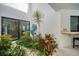 Landscaped garden with tropical plants and a seahorse sculpture at 5179 Flicker Field Cir, Sarasota, FL 34231