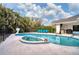 Inviting kidney-shaped pool with spa and blue lounge chairs at 5179 Flicker Field Cir, Sarasota, FL 34231