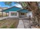 Adorable teal home with a covered porch and large tree at 554 Canal Rd, Sarasota, FL 34242