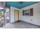 Covered front porch with yellow door and blue ceiling at 554 Canal Rd, Sarasota, FL 34242