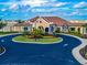 Community clubhouse with landscaped grounds and circular driveway at 5904 Wake Forest Run # 102, Bradenton, FL 34211