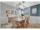 Bright dining room with a large wooden table and modern chandelier at 5904 Wake Forest Run # 102, Bradenton, FL 34211