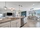 Open concept kitchen with granite island, stainless steel appliances, and view of dining area at 5904 Wake Forest Run # 102, Bradenton, FL 34211