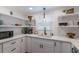 White kitchen with quartz countertops, open shelving, and a farmhouse sink at 600 Fox St, Longboat Key, FL 34228