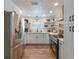 Modern kitchen featuring white cabinets, stainless steel appliances, and wood-look tile floors at 600 Fox St, Longboat Key, FL 34228