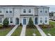 Townhouse exterior with a landscaped yard and blue door at 6111 Fairmont Ln, Palmetto, FL 34221