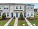 Three-unit townhome building with gray siding, blue doors, and landscaping at 6111 Fairmont Ln, Palmetto, FL 34221