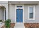 Blue front door with white trim and landscaping at 6111 Fairmont Ln, Palmetto, FL 34221