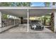 Covered carport with parking for one car, concrete flooring, and a decorative block wall at 6231 Beechwood Ave, Sarasota, FL 34231