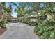 Mid-century home with carport, surrounded by tropical foliage at 6231 Beechwood Ave, Sarasota, FL 34231