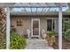 Inviting front entrance with pergola, lush landscaping, and decorative pots at 6231 Beechwood Ave, Sarasota, FL 34231
