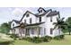 Two-story farmhouse with white siding, black accents, and a large front porch at 639 Oakford Rd, Sarasota, FL 34240