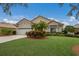 One-story house with tile roof, two-car garage, and lush landscaping at 6726 Virginia Xing, University Park, FL 34201