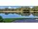 Serene lake view with tree reflections and a grassy shoreline at 6726 Virginia Xing, University Park, FL 34201