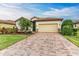 Single-story home with a brick driveway and landscaped front yard at 6933 Quiet Creek Dr, Bradenton, FL 34212
