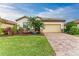 Well-maintained front yard with tropical landscaping and paver driveway at 6933 Quiet Creek Dr, Bradenton, FL 34212