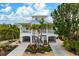 Two-story house with a light yellow exterior, palm trees, and a landscaped yard at 727 Holly Rd, Anna Maria, FL 34216