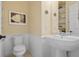 Guest bathroom with pedestal sink and white toilet at 727 Holly Rd, Anna Maria, FL 34216