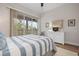 Bedroom with white dresser, striped bedding, and access to a balcony at 727 Holly Rd, Anna Maria, FL 34216