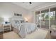 Bright bedroom with striped bedding, private balcony, and wood floors at 727 Holly Rd, Anna Maria, FL 34216