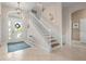 Bright entryway with a tiled floor, grand staircase, and chandelier at 727 Holly Rd, Anna Maria, FL 34216