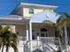 Two-story beach house with light yellow and blue siding at 727 Holly Rd, Anna Maria, FL 34216